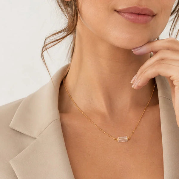 Collier cristal de roche LUMIA® porté par une femme, tube en cristal de roche sur chaîne dorée