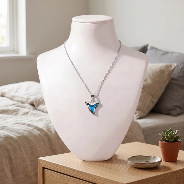 Collier dent de requin bleu en nacre naturelle porté sur un buste, pendentif dent de requin sur chaîne argentée