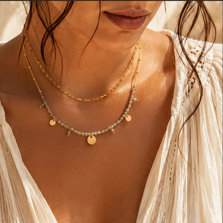 Collier double rang en labradorite porté par une femme, chaîne et perles dorées