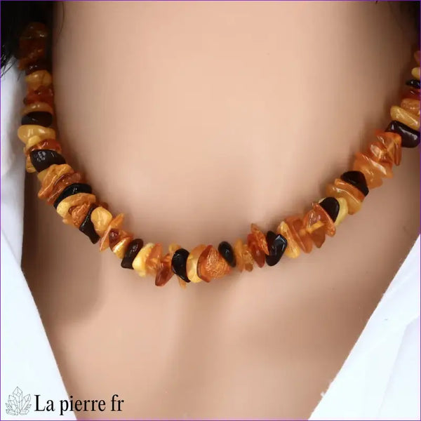Collier en Ambre baroque multicolore porté au cou, illustrant son style naturel et sa palette de couleurs chaudes.