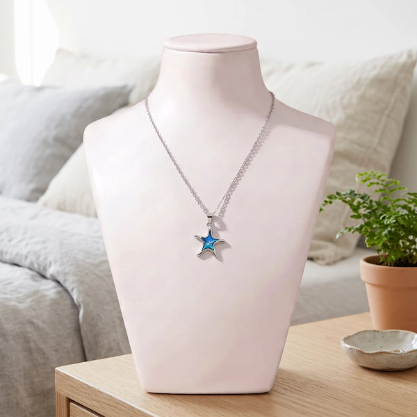 Collier étoile de mer bleu en nacre naturelle porté sur un buste, pendentif étoile de mer sur chaîne argentée