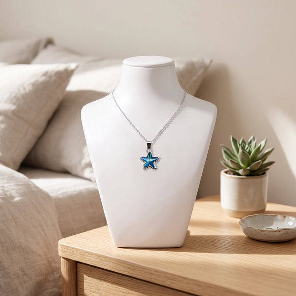 Collier fleur bleu en nacre naturelle porté sur un buste, pendentif fleur sur chaîne argentée
