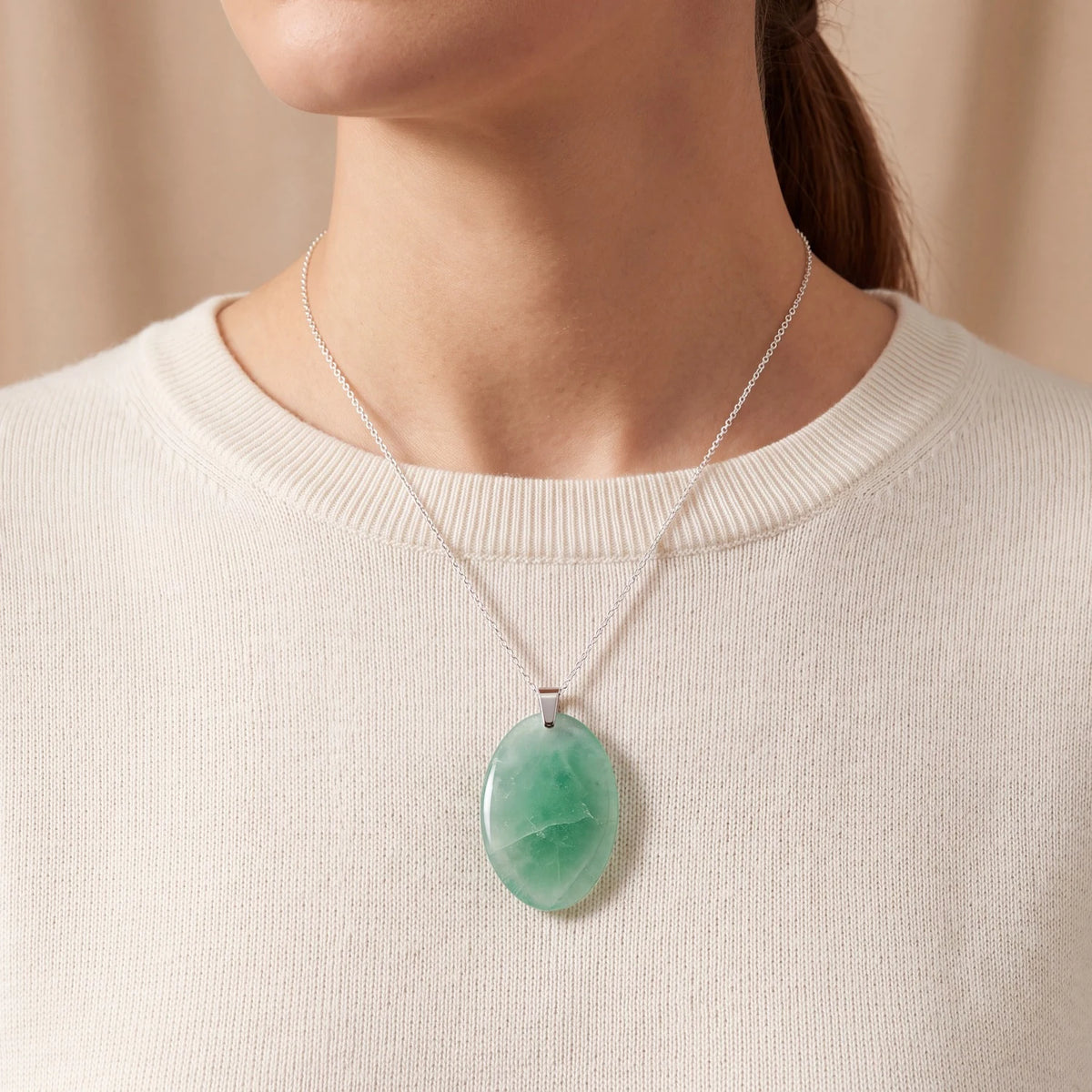 Collier pierre fluorite porté par une femme, pendentif ovale vert plat sur chaîne