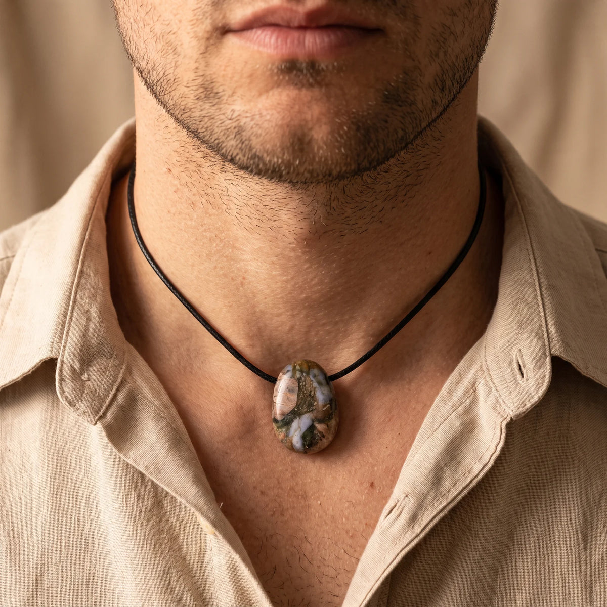 Collier homme pendentif pierre percée en libérite sur cordon noir