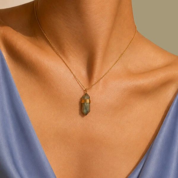 Collier labradorite femme porté sur une robe bleue, pendentif pointe grise et dorée