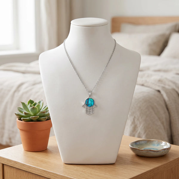 Collier main de Fatma bleu en nacre naturelle porté sur un buste, pendentif main de Fatma sur chaîne argentée