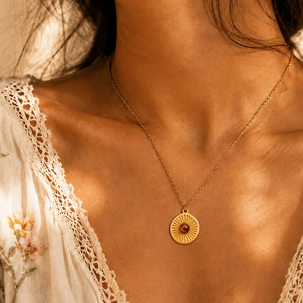 Collier œil de tigre SOLAYA® porté par une femme, médaille soleil sur chaîne fine