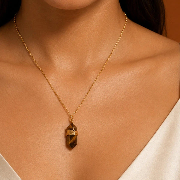 Collier œil de tigre femme porté sur chemisier blanc, pendentif pointe brune et dorée