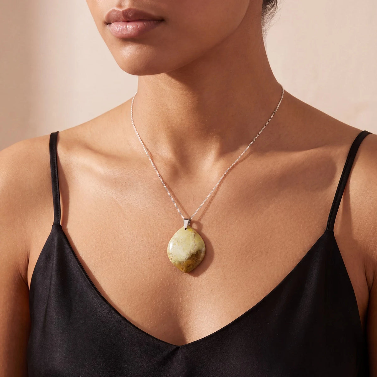 Bijou opale verte porté par une femme, pendentif plat forme libre vert sauge