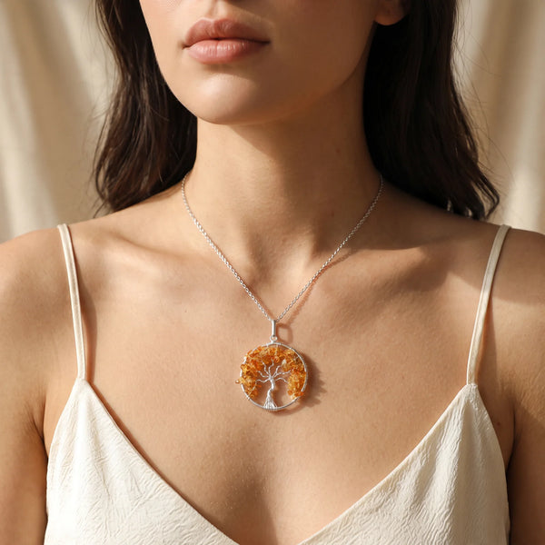 Collier pendentif arbre de vie en citrine chauffée porté par une femme, chaîne argentée