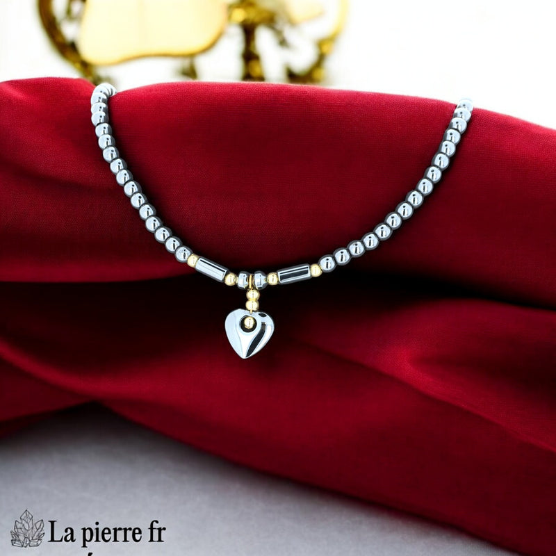 Détail du pendentif cœur en hématite polie et perle dorée centrale