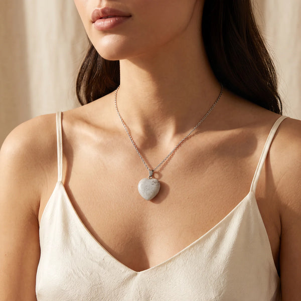 Collier pendentif cœur en labradorite grise naturelle porté par une femme, chaîne argentée