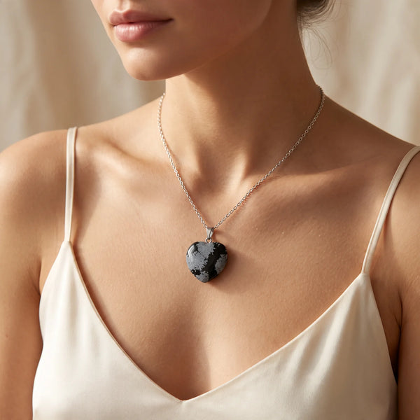 Collier pendentif cœur en obsidienne flocon de neige porté par une femme, chaîne argentée