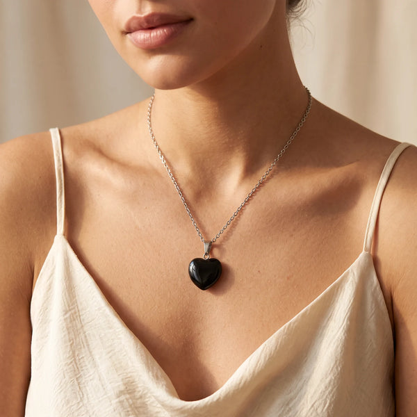 Collier pendentif cœur en obsidienne œil céleste noire porté par une femme