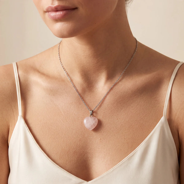 Collier pendentif cœur en quartz rose naturel porté par une femme, chaîne argentée