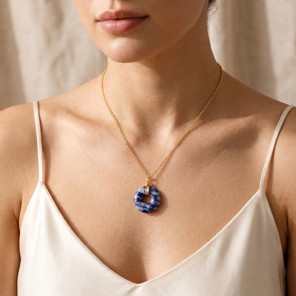 Collier pendentif pierre bleue en sodalite porté sur une chaîne dorée femme