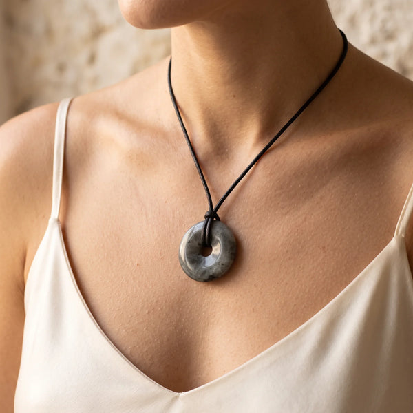 Collier pendentif donut en labradorite grise naturelle porté par une femme, cordon noir
