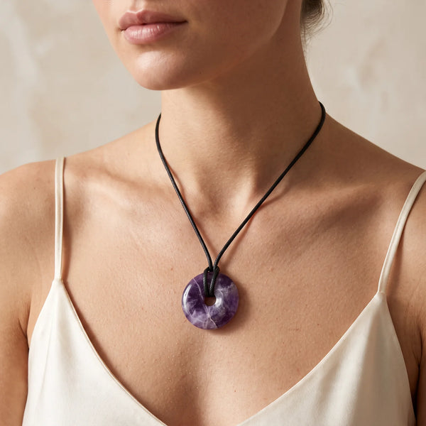 Collier pendentif donut en améthyste chevron naturelle porté par une femme, cordon noir