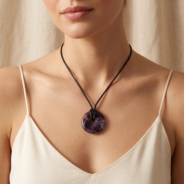 Collier pendentif donut en améthyste naturelle porté par une femme, cordon ciré noir
