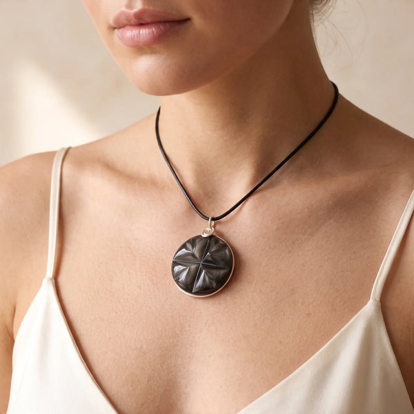 Collier pendentif étoile en obsidienne oeil céleste porté par une femme