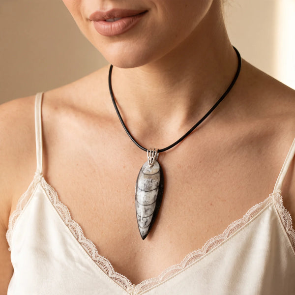Collier pendentif fossile d'orthocéras naturel porté par une femme, cordon cuir noir
