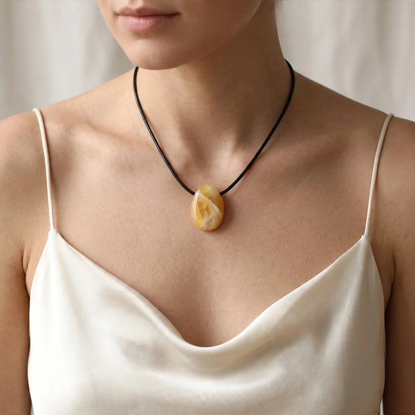 Collier pendentif pierre percée en aventurine jaune naturelle porté par une femme
