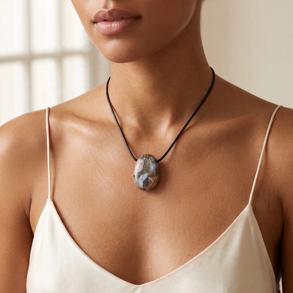 Collier pendentif pierre percée en libérite naturelle porté par une femme, cordon noir
