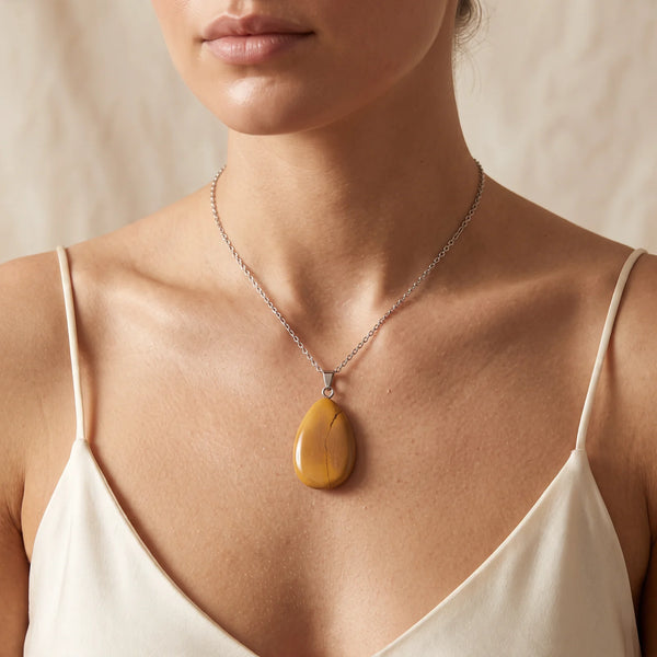 Collier pendentif goutte en jaspe mokaïte jaune porté par une femme