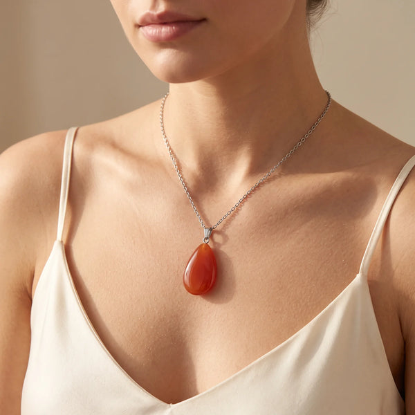 Collier pendentif goutte en cornaline orange portée par une femme, bélière argentée