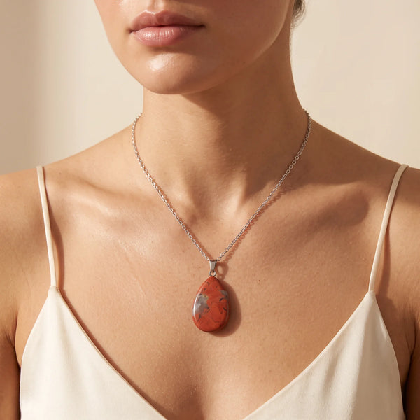 Collier pendentif rouge en jaspe naturel forme goutte porté par une femme