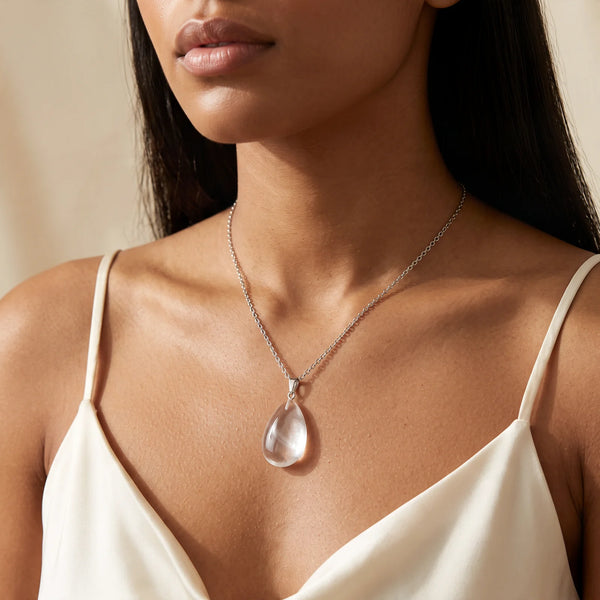 Collier pendentif goutte en cristal de roche naturel porté par une femme, chaîne argentée