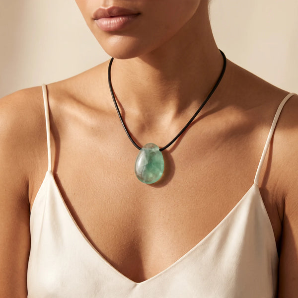 Collier pendentif goutte en fluorine verte naturelle porté par une femme, cordon noir