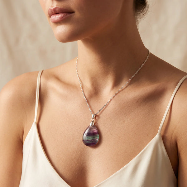 Collier pendentif goutte en fluorite naturelle violette et verte porté par une femme