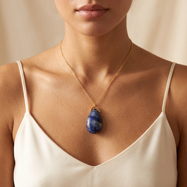 Collier pendentif larme en sodalite naturelle porté par une femme, chaîne dorée