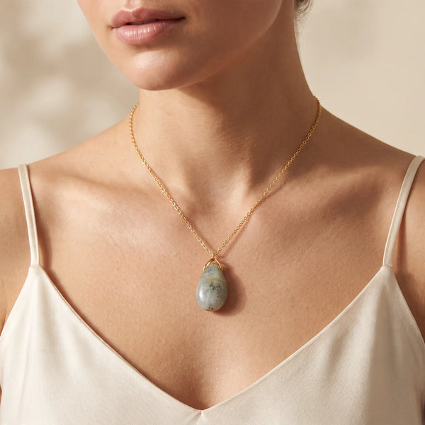 Collier pendentif larme en labradorite grise naturelle porté par une femme, chaîne dorée