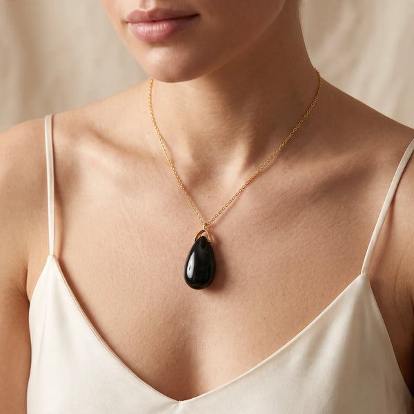 Collier pendentif larme en agate mousse naturelle porté par une femme, chaîne dorée