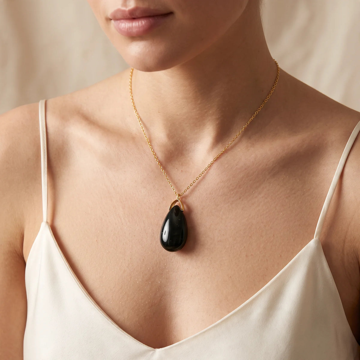 Collier pendentif larme en agate mousse naturelle porté par une femme, chaîne dorée