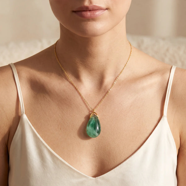 Collier pendentif larme en fluorine verte naturelle porté par une femme, chaîne dorée