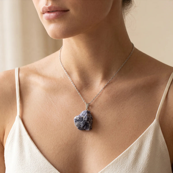 Collier pendentif pierre brute en cordiérite violette porté par une femme