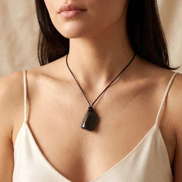 Collier pendentif pierre roulée en shungite naturelle porté par une femme, cordon noir