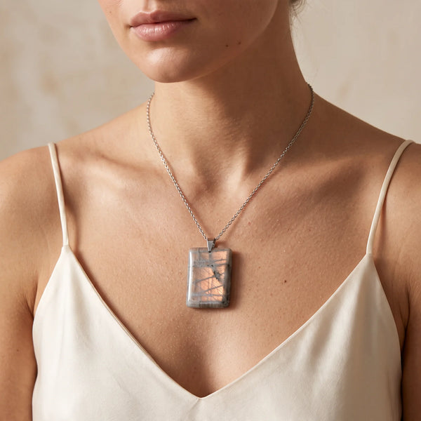 Collier pendentif plaque en labradorite naturelle porté par une femme, chaîne acier