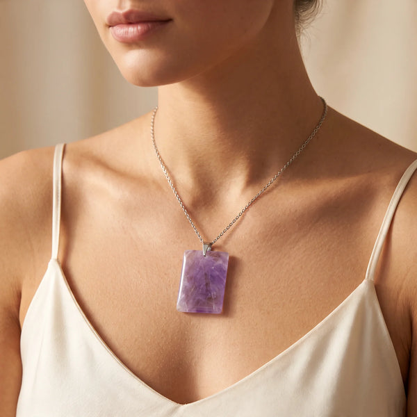 Collier pendentif pierre plate en améthyste naturelle porté par une femme, chaîne acier