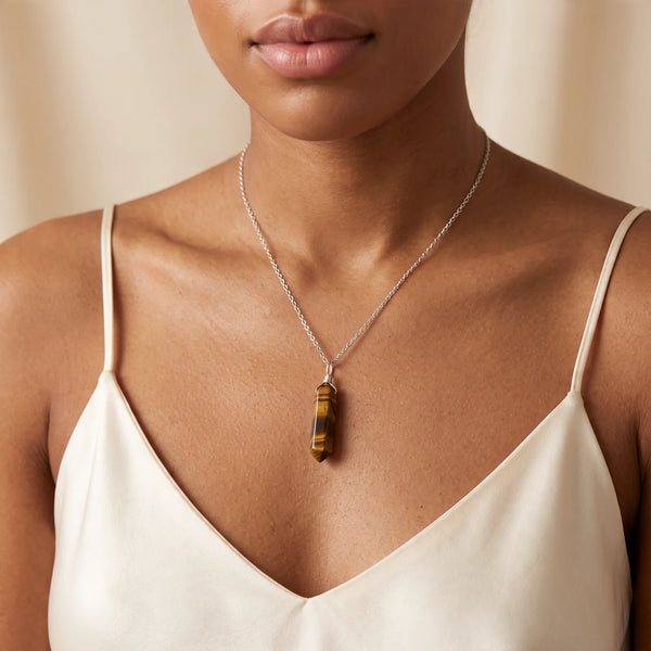 Collier pendentif pointe en œil de tigre naturel porté par une femme, chaîne argentée