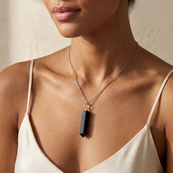Collier pendentif pointe en onyx noir naturel porté par une femme, chaîne argentée