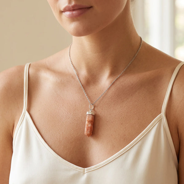 Collier pendentif pointe en pierre de soleil naturelle porté par une femme, chaîne argentée