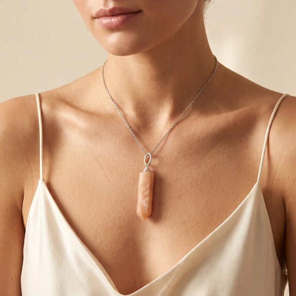 Collier pendentif pointe en pierre de lune rose naturelle porté par une femme