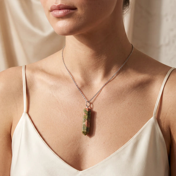 Collier pendentif pointe en unakite naturelle porté par une femme, chaîne argentée