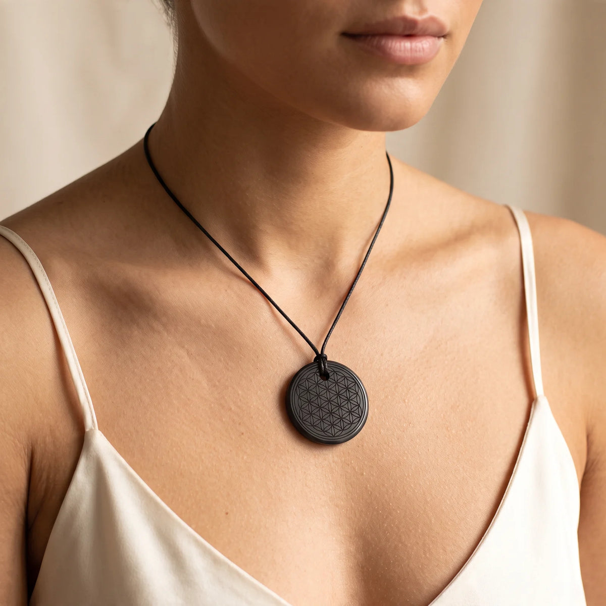 Collier pendentif rond fleur de vie en shungite naturelle porté par une femme, cordon noir
