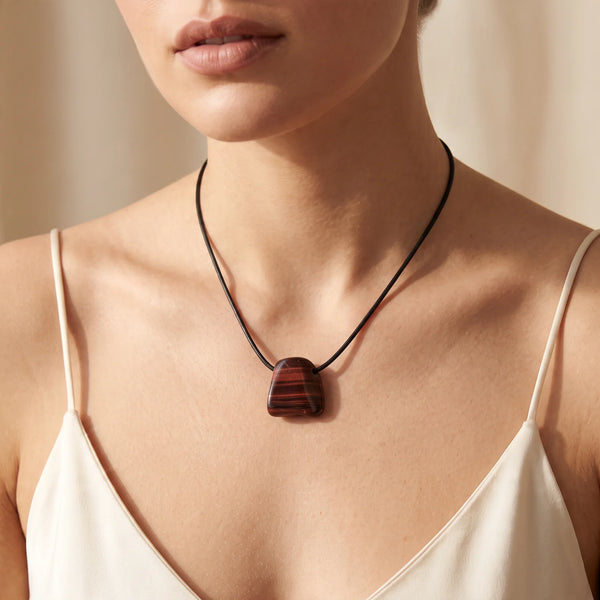 Collier pendentif roulé percé en œil de taureau naturel porté par une femme, cordon noir