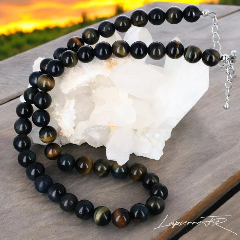 Collier en pierre naturelle d’Œil de Faucon, bijou de lithothérapie pour femme. Véritable pierre bleue grisée en perles rondes, symbole de protection, d’intuition et de lucidité intérieure.